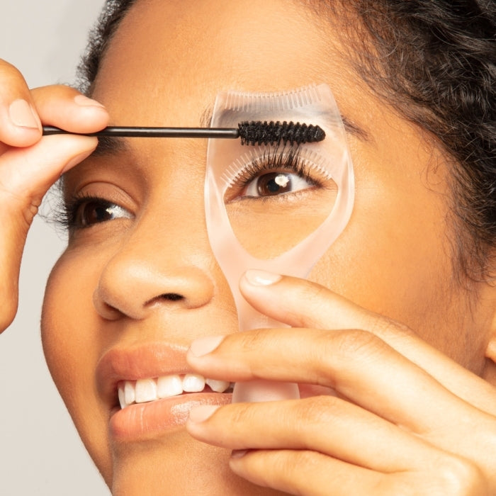 Close-up of a person using the Lash Guard & Comb | Tweezerman to separate and groom eyelashes while applying mascara for a precise and clump-free look.