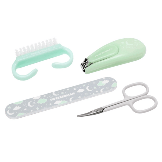 Baby Manicure Kit | Tweezerman with mint green nail clipper, white baby nail scissors, grey nail file with moon and cloud patterns, and a small nail brush for gentle care.