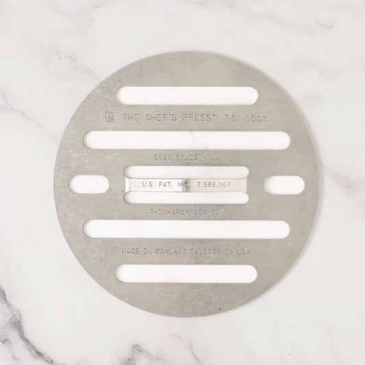 Metallic kitchen press on a marble surface