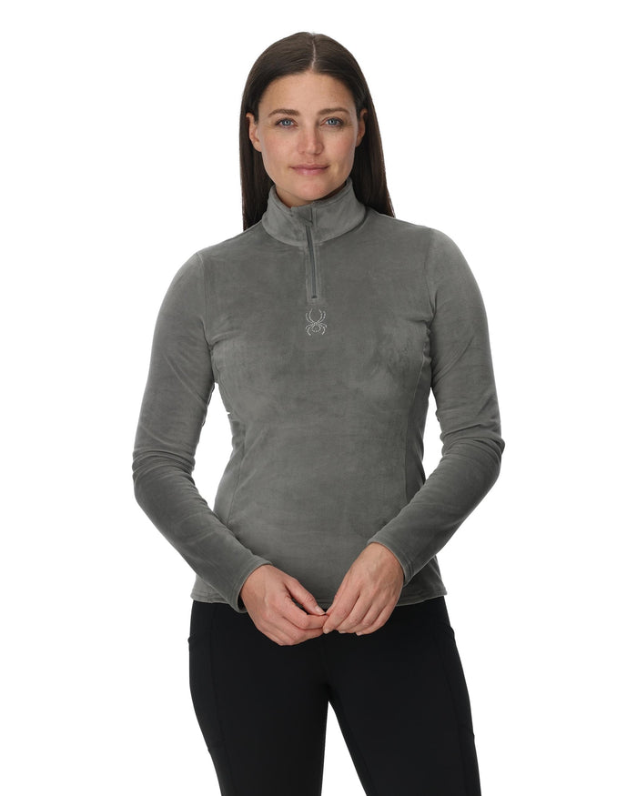 Woman wearing a gray long-sleeve shirt with a quarter zip on a white background